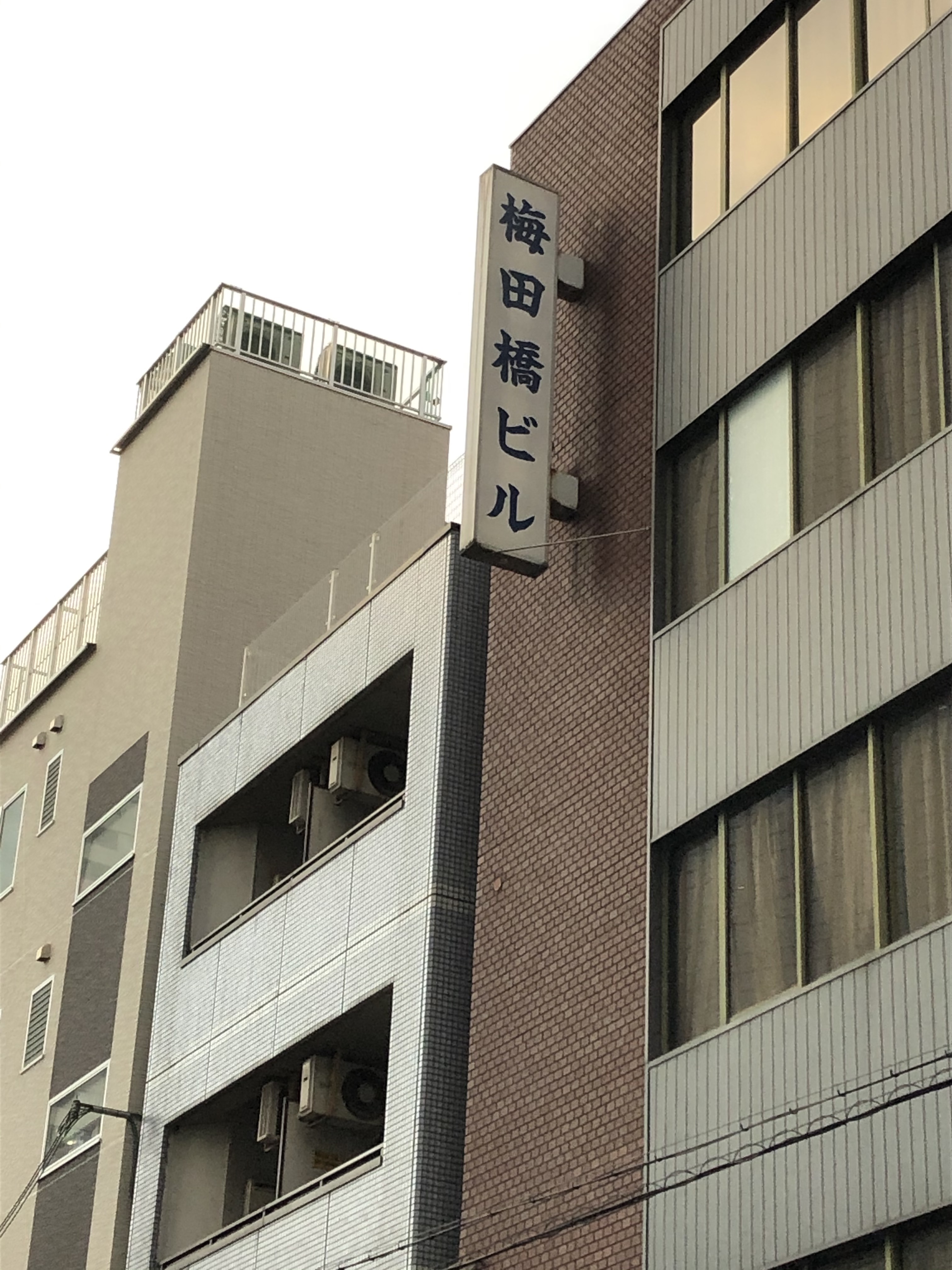 ここに梅田橋があったことを唯一、伝えてくれる「梅田橋ビル」の看板